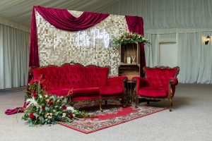 Glamorous red velvet seating area with gold backdrop at Applewood Hall