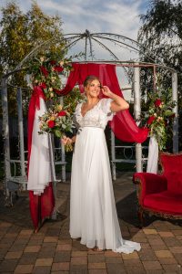 Winter bride with bouquet in romantic ivory boho dress